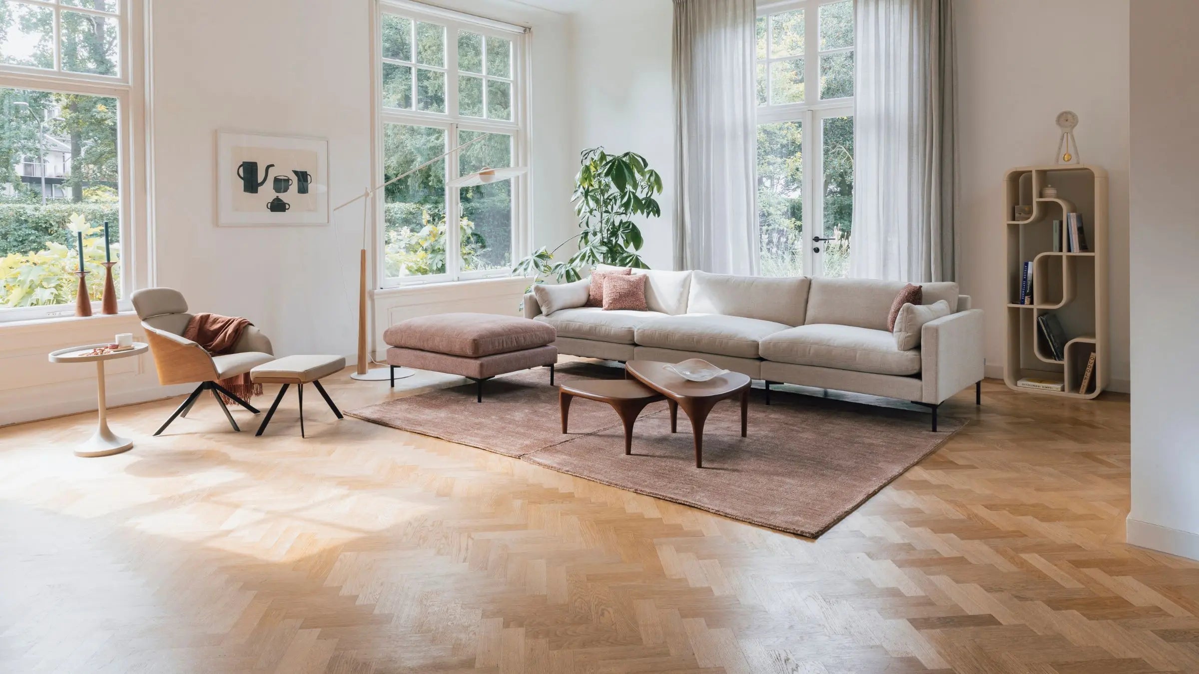 Minimalist living room decor with 3 seat sofa, pouffe and armchair with footstool and pebble shaped nesting tables