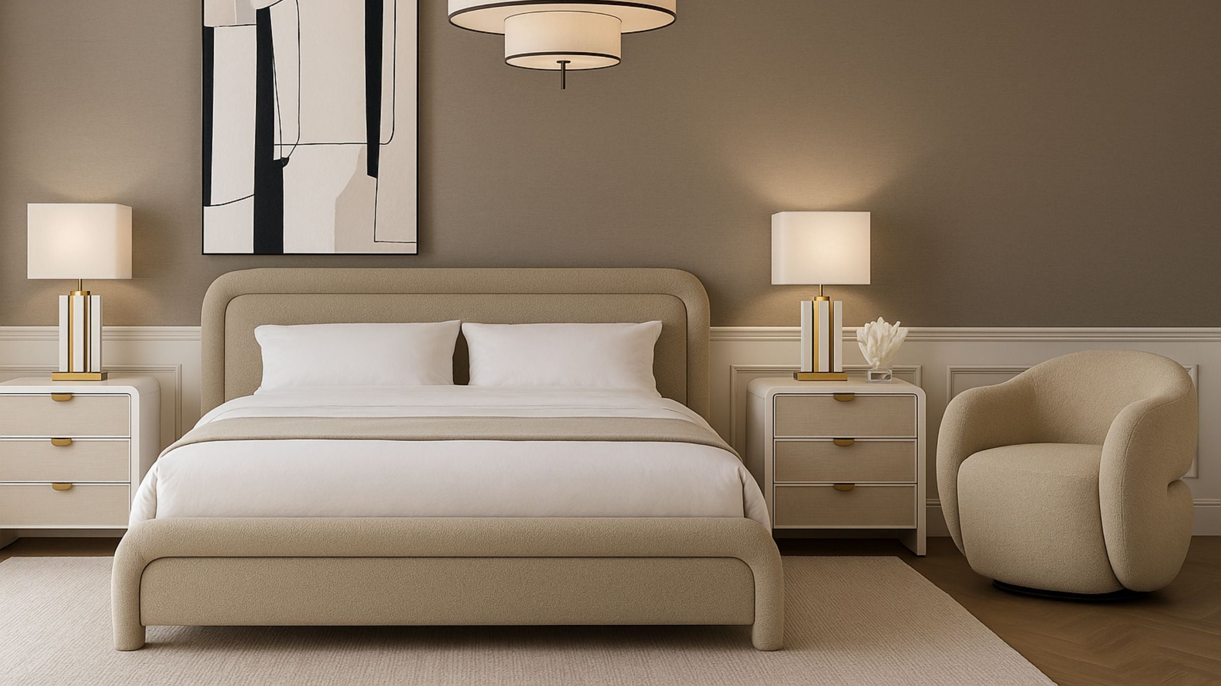 Bedroom setting in a neutral beige colour palette with an upholstered bed, matching accent chair and white bedside tables either side with white lamps