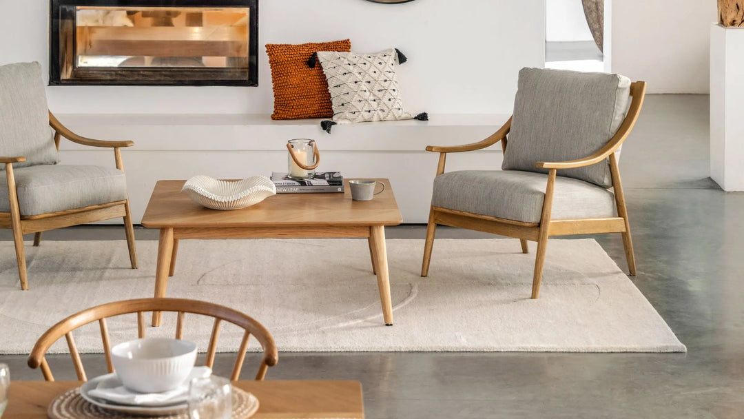 Image of living room setting with mid century style armchairs and coffee table with decorative ornaments on