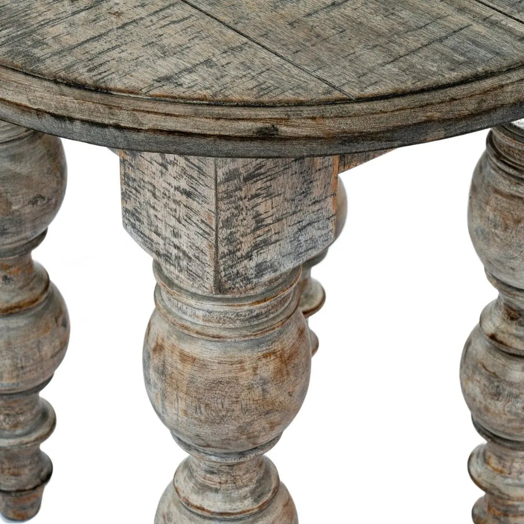 Close up of round wooden table with aged, rustic finish on a white background