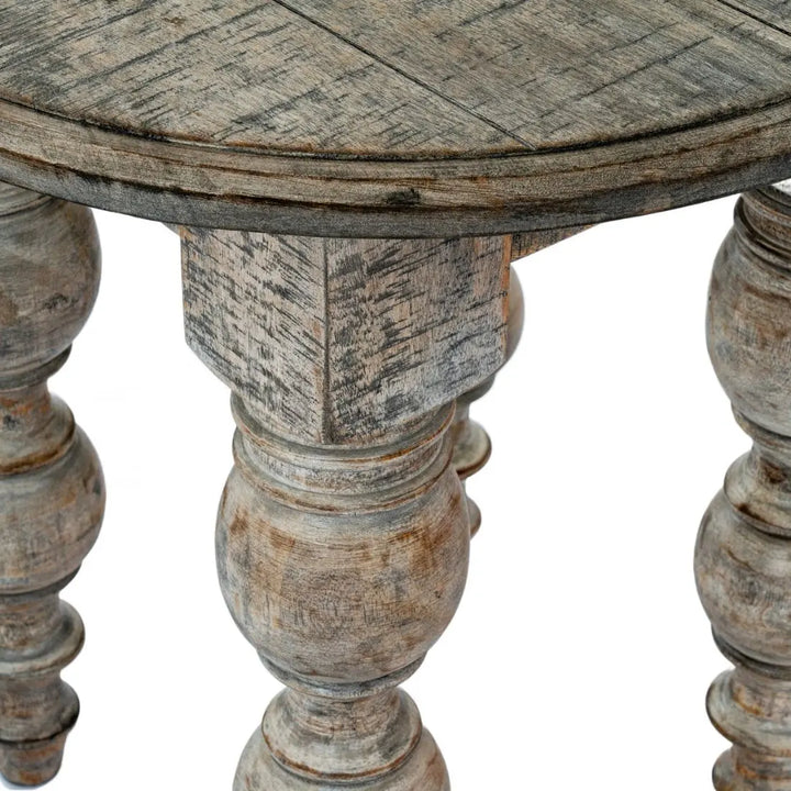 Close up of round wooden table with aged, rustic finish on a white background