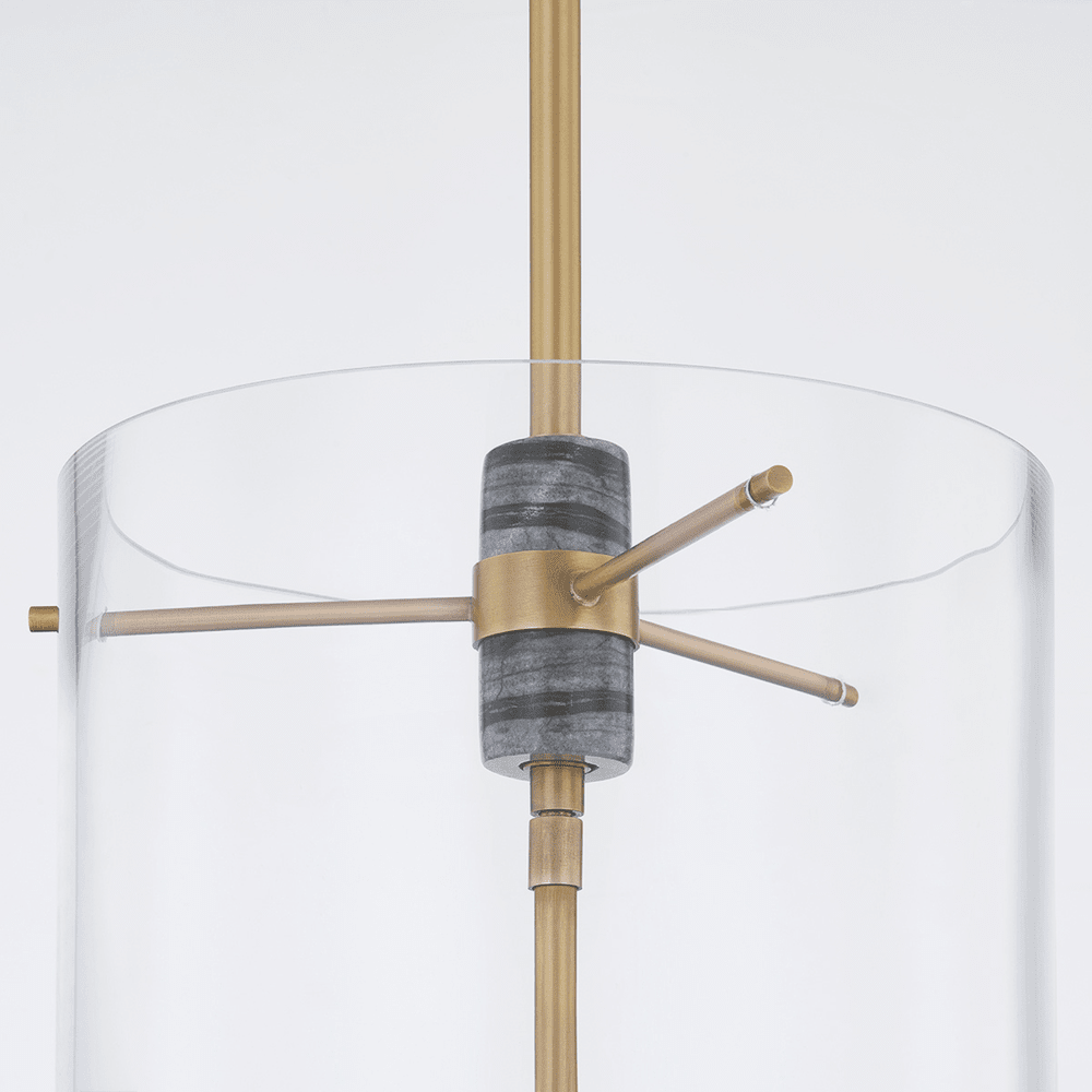 The Adonis Lantern Light - Brass features a modern lantern silhouette with a cylindrical clear glass shade, Vintage Brass rod and accents, and a central gray textured element, photographed against a plain white background.