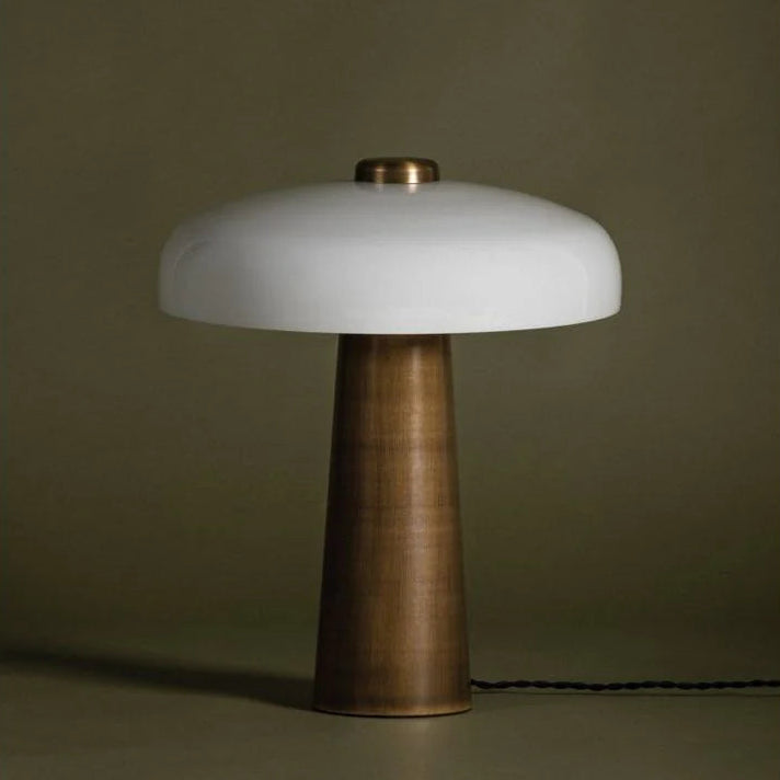 Table lamp with white shade and bronze base on a dark background