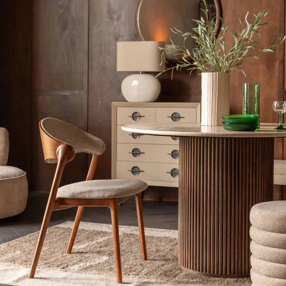 Modern interior with a wooden chair, round table, and decorative items.