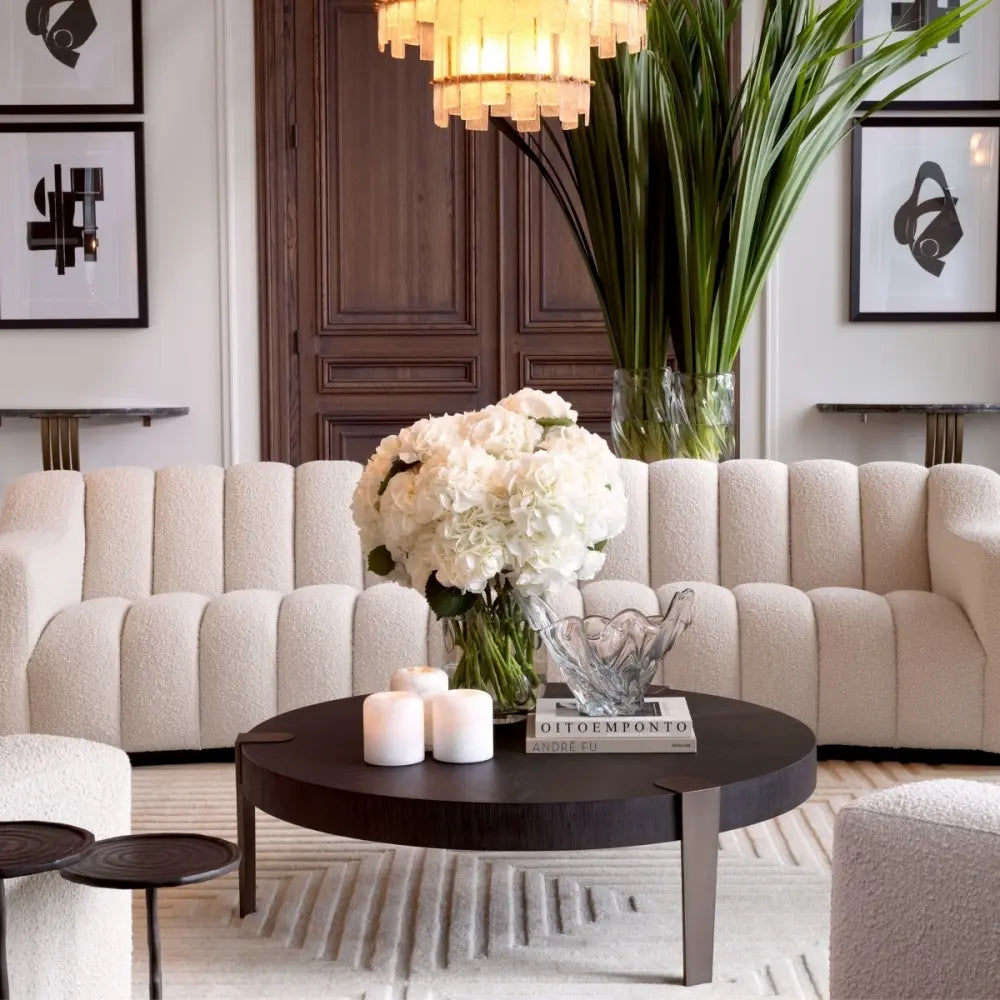 Modern living room with beige sofa, round coffee table, and decorative elements.
