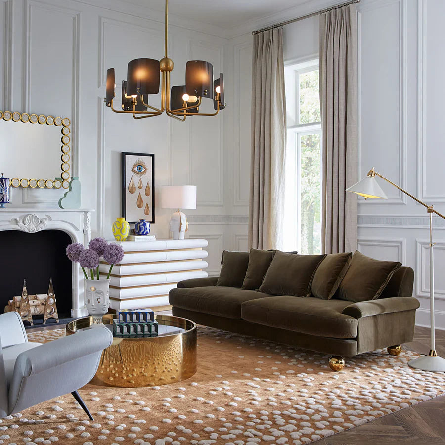 Luxurious living room with a brown sofa, gold coffee table, and decorative elements.