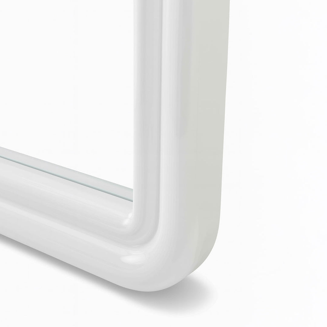 Close up of corner of curved white mirror