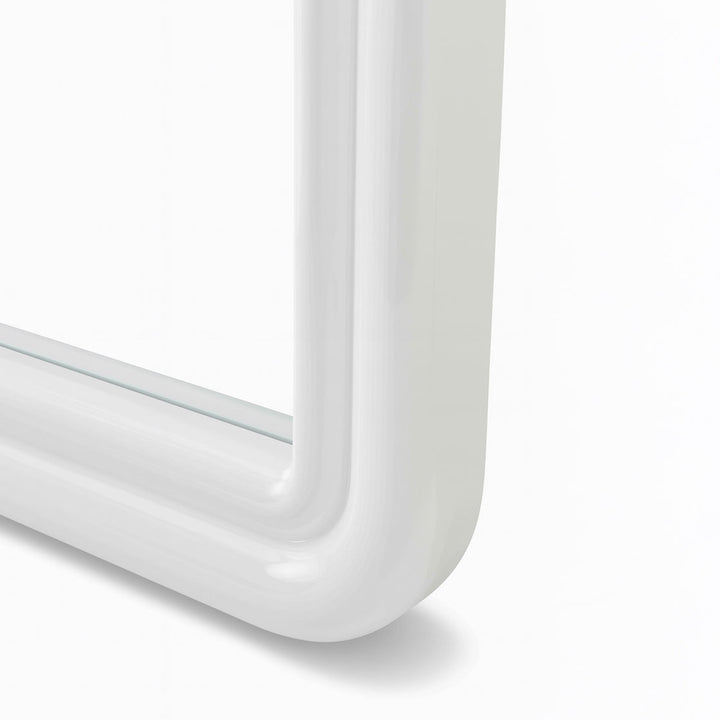 Close up of corner of curved white mirror