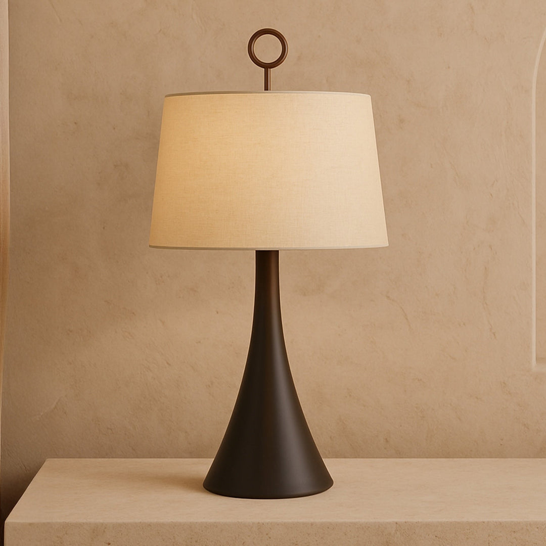 Wooden base table lamp with neutral linen shade on a neutral background