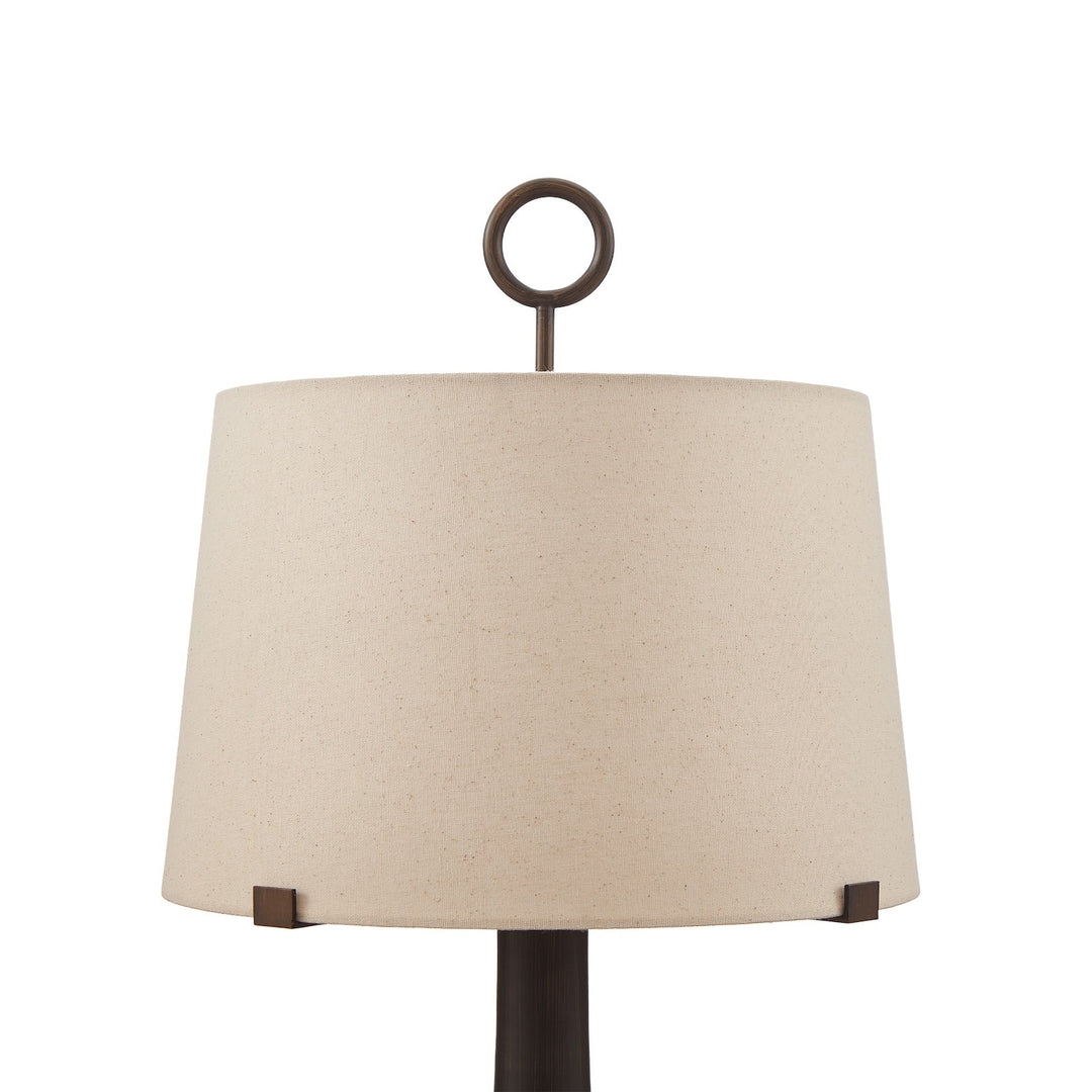 Close up of a wooden base table lamp with neutral linen shade on a white background