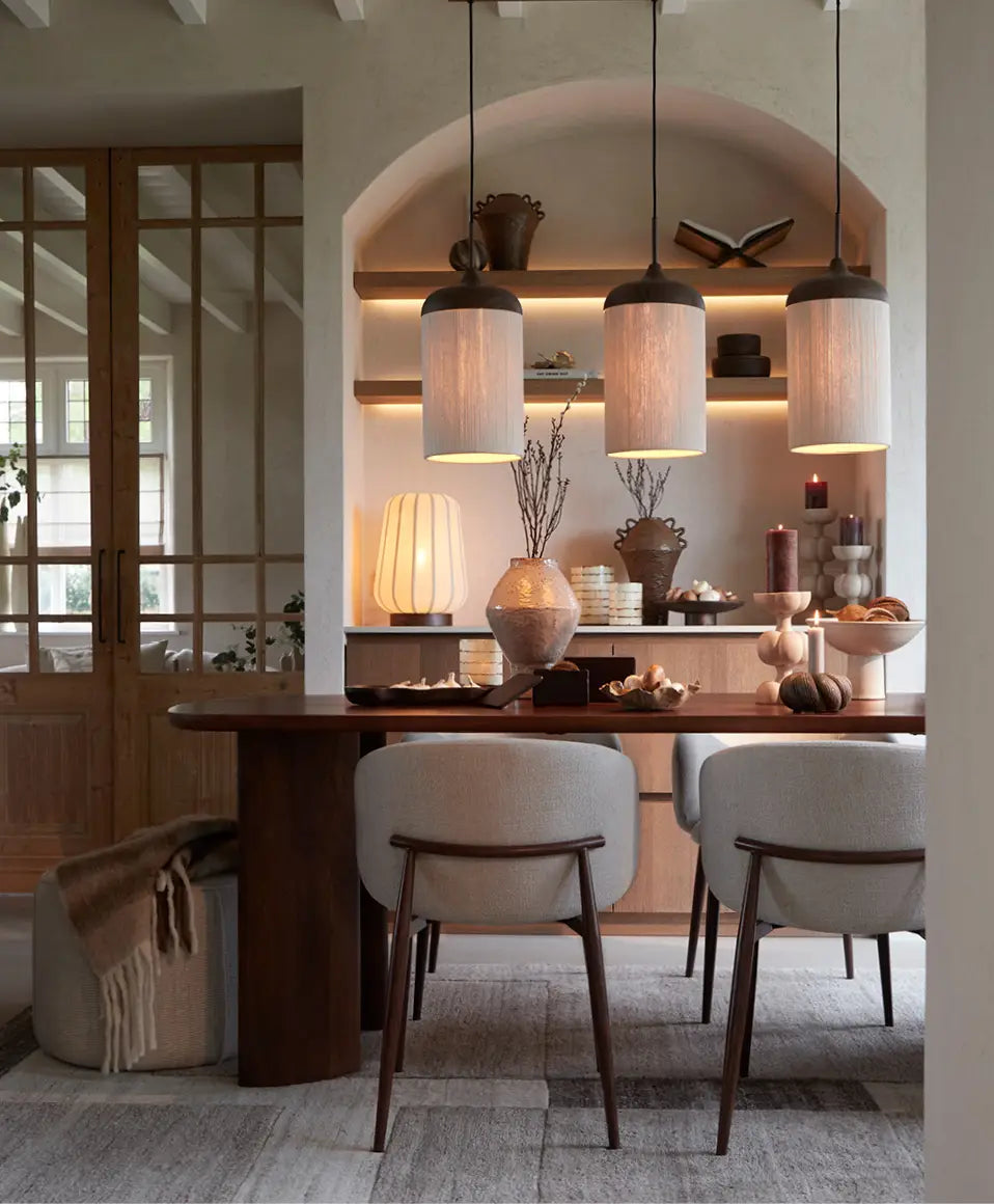 Dining room with wooden table, chairs, and decorative elements.