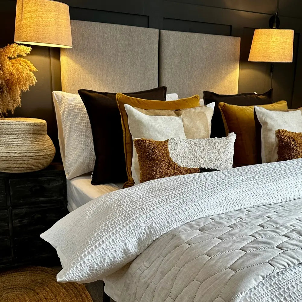 Bed with decorative pillows and lamps in a bedroom setting