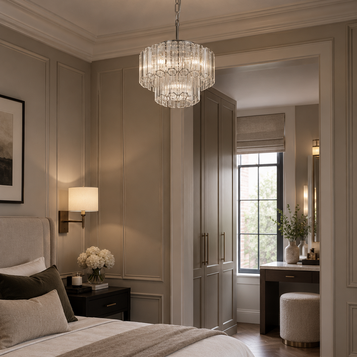 A luxury bedroom interior featuring a tiered crystal chandelier hanging from the ceiling, a neatly made bed with neutral-toned bedding, and elegant room details.