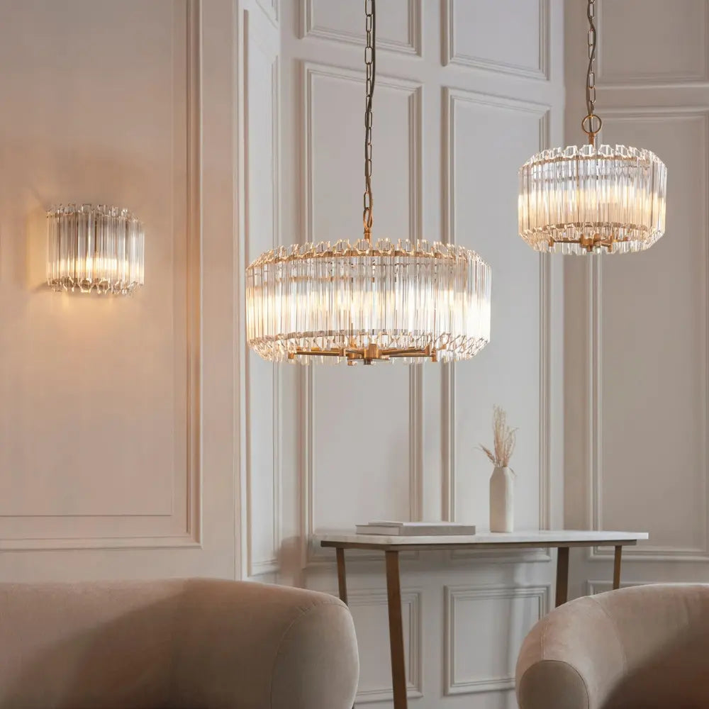 Luxurious chandelier and wall lights in a stylish room with neutral decor.