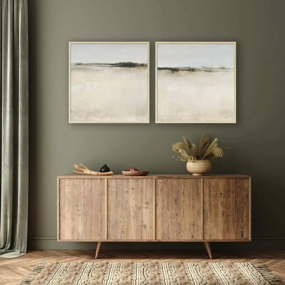 Wooden sideboard with decorative items against a green wall with two framed artworks.