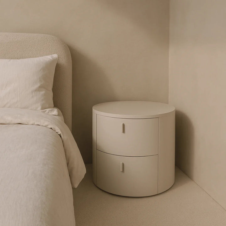 Beige nightstand next to a bed in a minimalistic bedroom