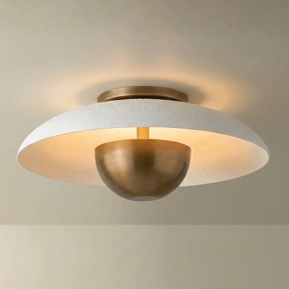 Ceiling light fixture with white textured shade and gold metal base on a beige background
