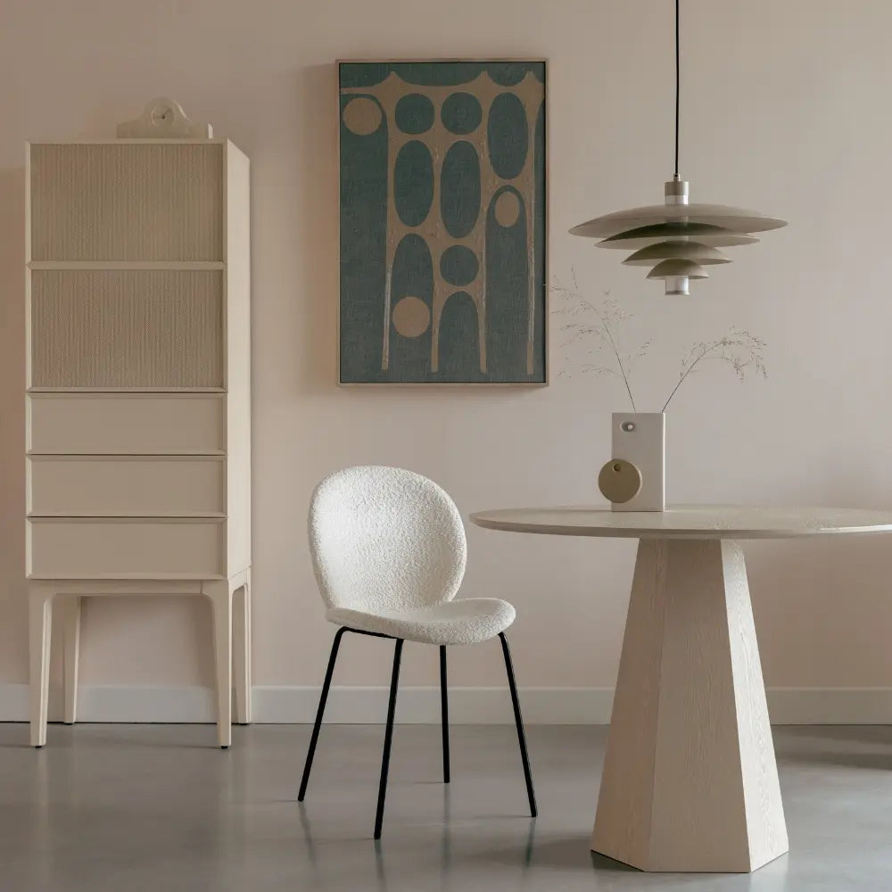 Modern interior with a chair, table, and cabinet against a beige wall.