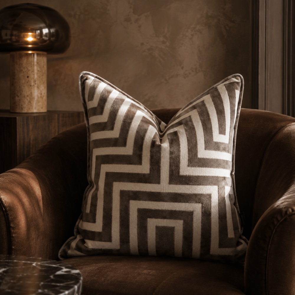 Decorative pillow with geometric pattern on a brown armchair