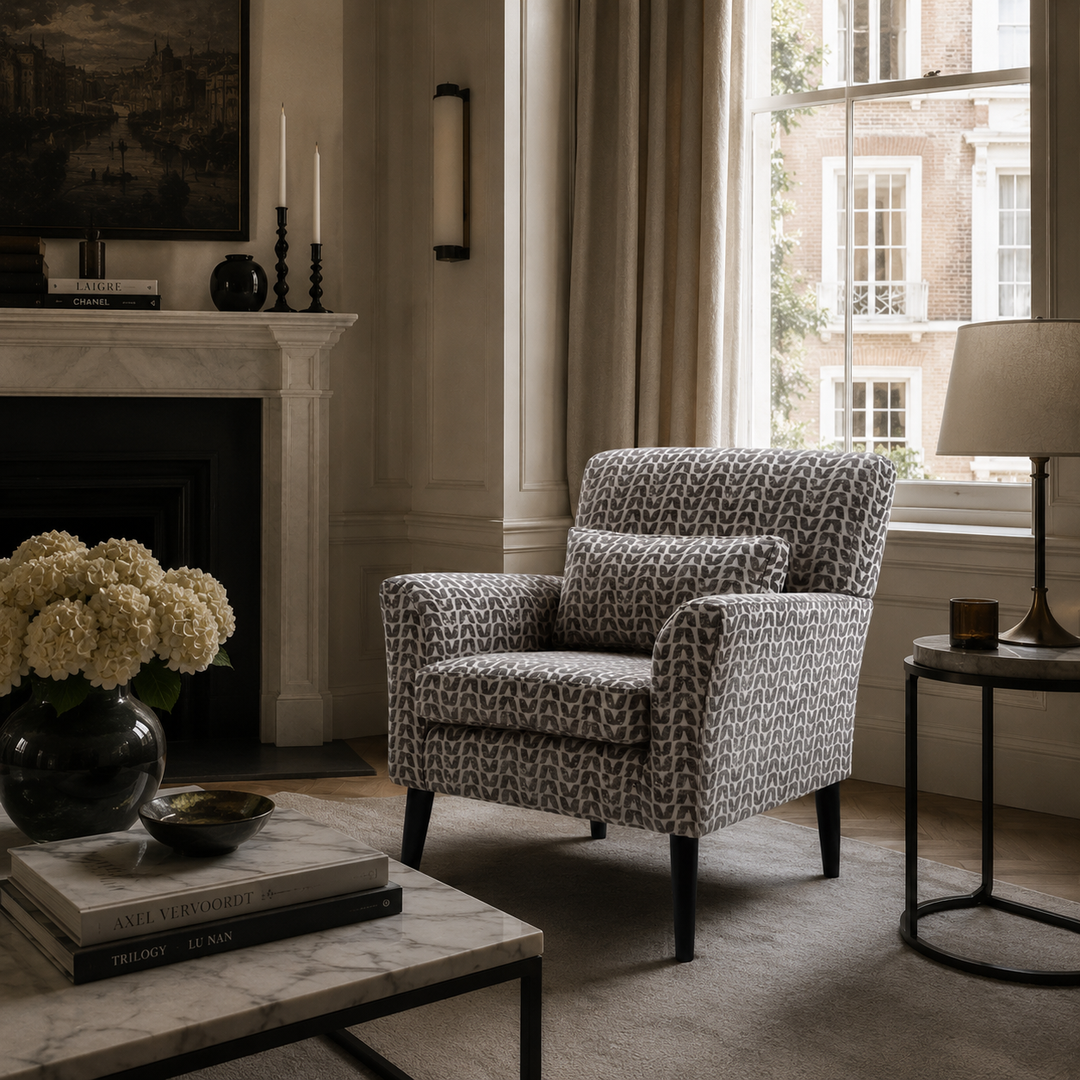 Patterned armchair in a living room with a fireplace and window.