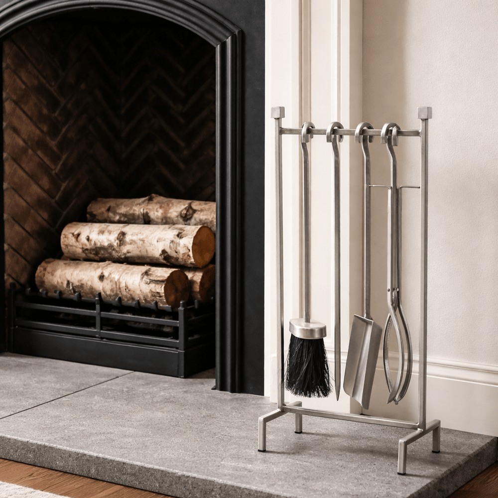 Fireplace with logs and a metal tool set on a stand.