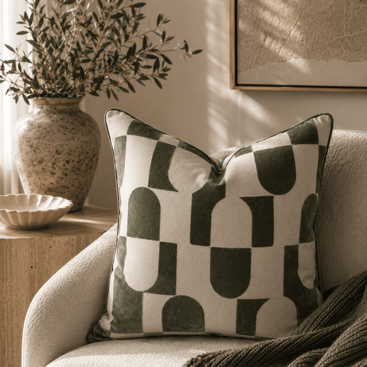 Decorative pillow with abstract pattern on a couch in a living room setting.
